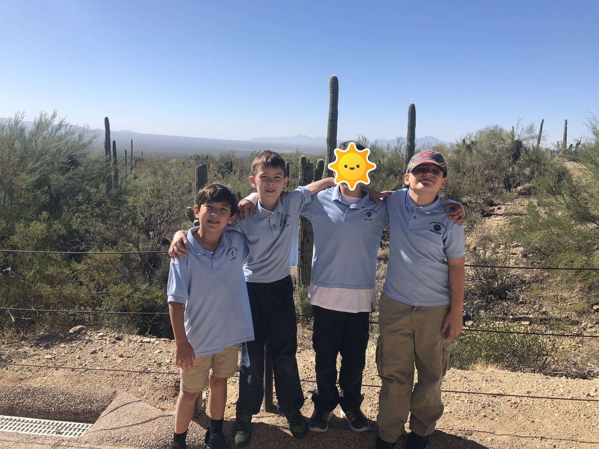 students pose in front of desert landscape 