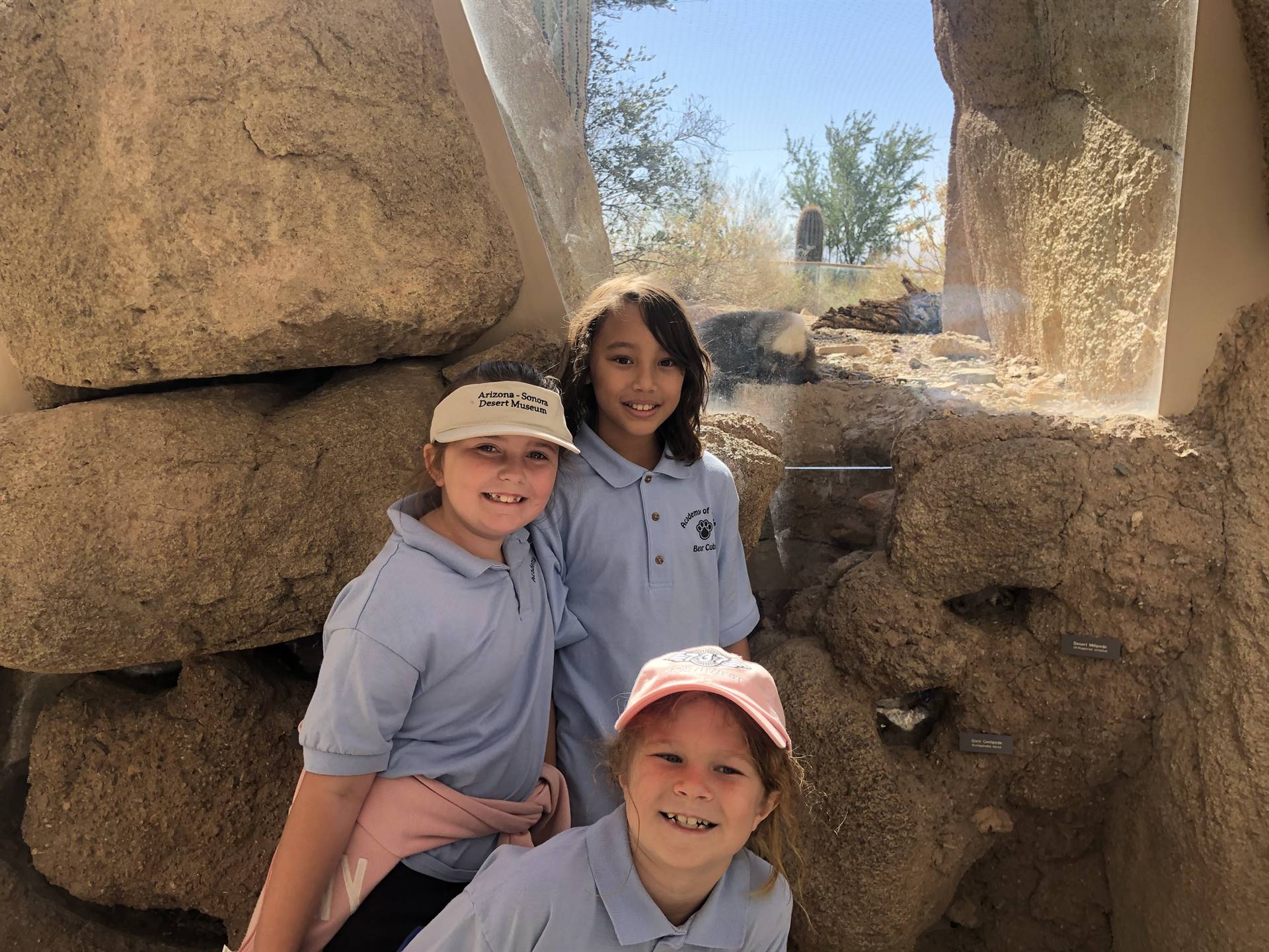 3 students near the prairie dog exhibit  