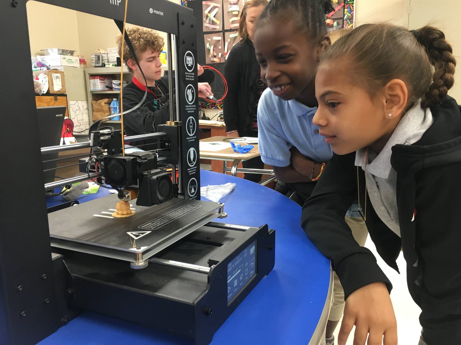 students look at 3d printer